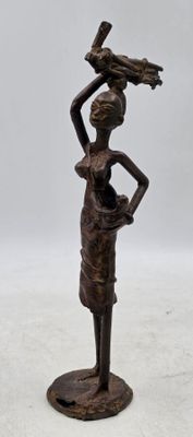 bronze statue of a woman holding a bird on her head