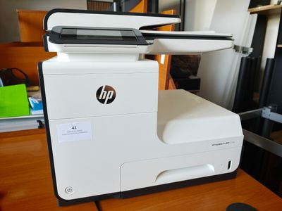 une imprimante posée sur un bureau, à côté d'une souris