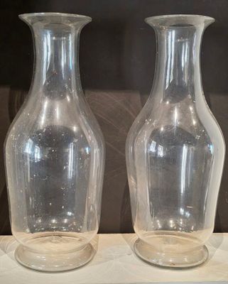 deux vases en verre posés l'un à côté de l'autre sur une étagère