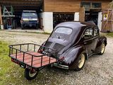 an old car with a trailer attached to it parked in front of a garage
