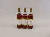 trois bouteilles de vin posées sur une surface blanche