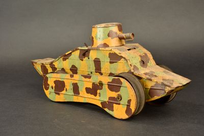 a wooden toy tank that has a camouflage pattern on it