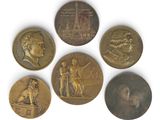 four different types of bronze medals on a white surface