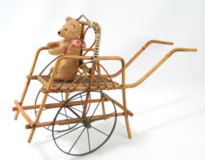 un ours en peluche assis dans un landau en osier