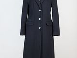 Ce manteau est en laine et comporte des boutons sur le revers.