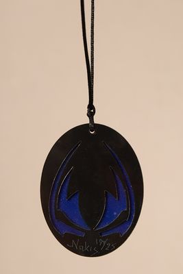 a close up of a black and blue ornament with a spider on it