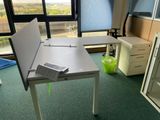 un bureau blanc sur lequel se trouve un livre, dans un bureau