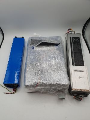 deux piles, un boîtier de piles et un ordinateur portable posés sur une table
