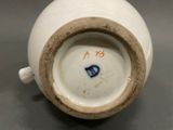 a close up of a white vase with blue writing on it