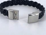 a close up of a black leather bracelet with two metal cubes on it