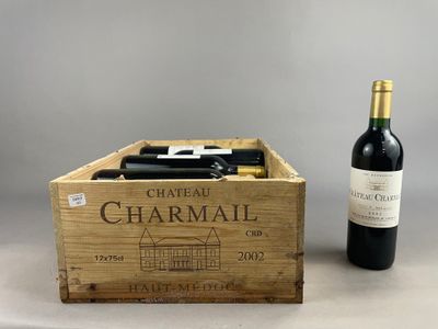 deux bouteilles de vin dans une caisse en bois, à côté d'une bouteille de vin