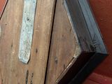 une boîte en bois munie d'une poignée en métal, posée sur un canapé rouge