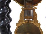 a close up of a clock with a pendulum on it