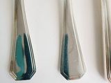 three spoons and a fork on a white table