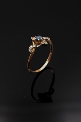 une image d'une bague en or avec une pierre bleue au centre