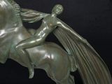 bronze statue of a woman riding a horse with a long mane