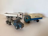 trois camions miniatures posés les uns à côté des autres sur une table
