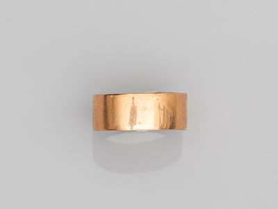 une image d'un anneau en or sur une surface blanche