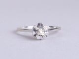 a close up of a diamond ring on a white surface