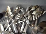 a lot of silver spoons and forks on the table