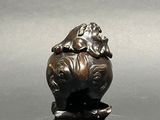 a small bronze figurine of a dog on a rock