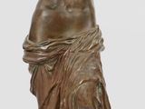 statue en bronze représentant une femme tenant un vase, posée sur un socle en bois