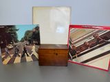 three beatles albums are sitting on a table next to a wooden box