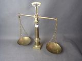 une balance ancienne en laiton comportant deux plateaux de chaque côté