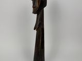 a wooden statue of a woman with a hood on her head