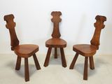 three wooden chairs sitting next to each other in a room