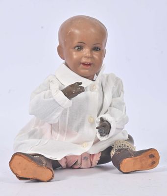 a baby doll sitting on the ground wearing a white shirt