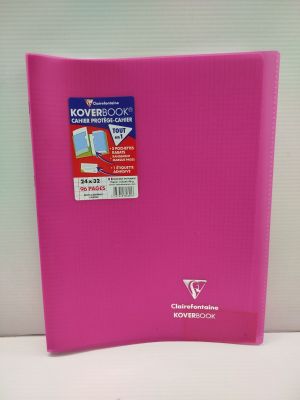 La couverture d'un cahier rose est ouverte sur une surface blanche