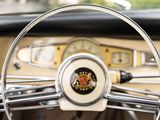 a steering wheel of a classic car with a crest on it