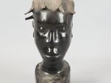 a sculpture of a man ' s head with a crown on it