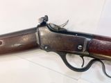 an old gun that is on display in a glass case