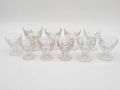 Plusieurs verres à pied et tasses sont alignés sur une surface blanche