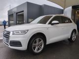 Le SUV Audi blanc est garé devant un immeuble.