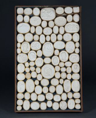 a white ceramic sculpture of a group of people surrounded by circles