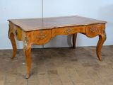 a wooden table with a marble top on a brick floor