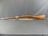 a rifle with a wooden barrel and a wooden handle on a gray background
