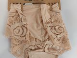 beige panties with lace and ruffles on a hanger on a white background