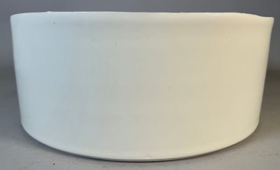a white bowl sitting on a table with a gray background