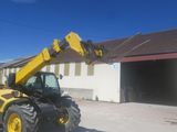 a yellow and black construction vehicle parked in front of a building