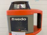 an image of a red and black laser level on top of a tripod