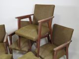 several chairs and stools are lined up against a white wall