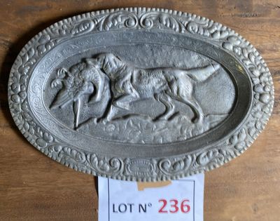 une plaque métallique sur laquelle figurent un chien et un homme