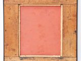 an old wooden picture frame with a red background on a white wall