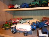 de nombreux camions miniatures posés sur une étagère dans une pièce