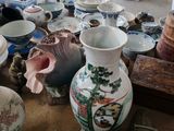 de nombreux vases et bols de toutes sortes sur la table