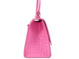 pink leather purse with a long strap on a white background